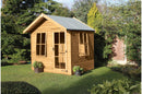 A wooden chalet summerhouse with a 6 pane Georgian door and windows set in a garden environment.